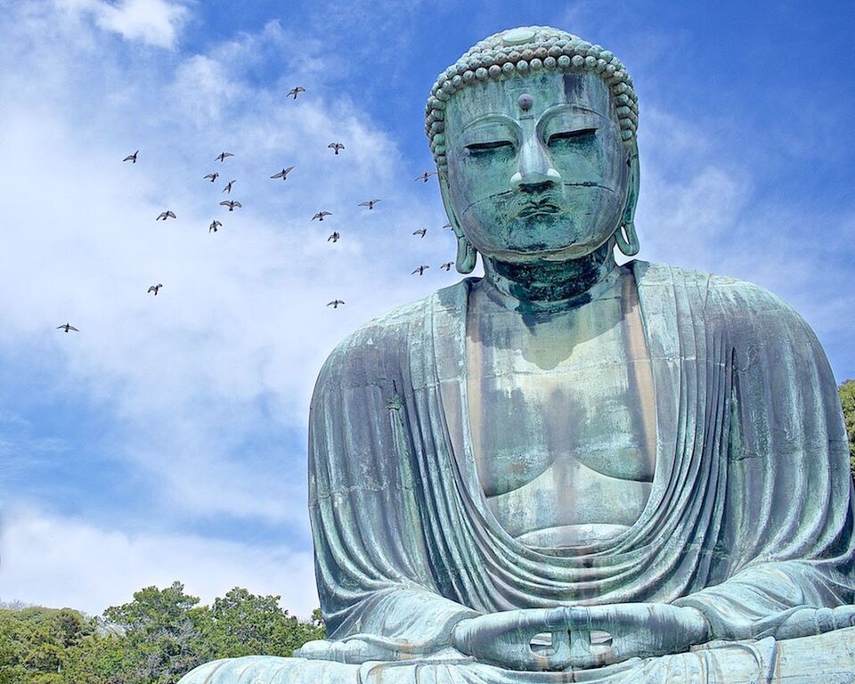 Low angle view of buddha statue in kotoku-in against cloudy sky