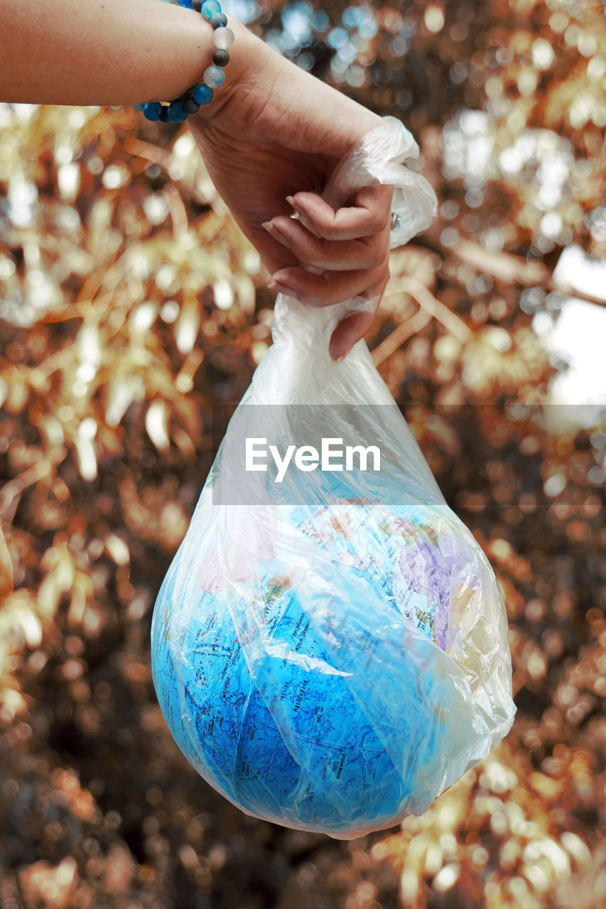 Concept of save earth from plastic waste pollution.  hand holding plastic bag with globe inside.