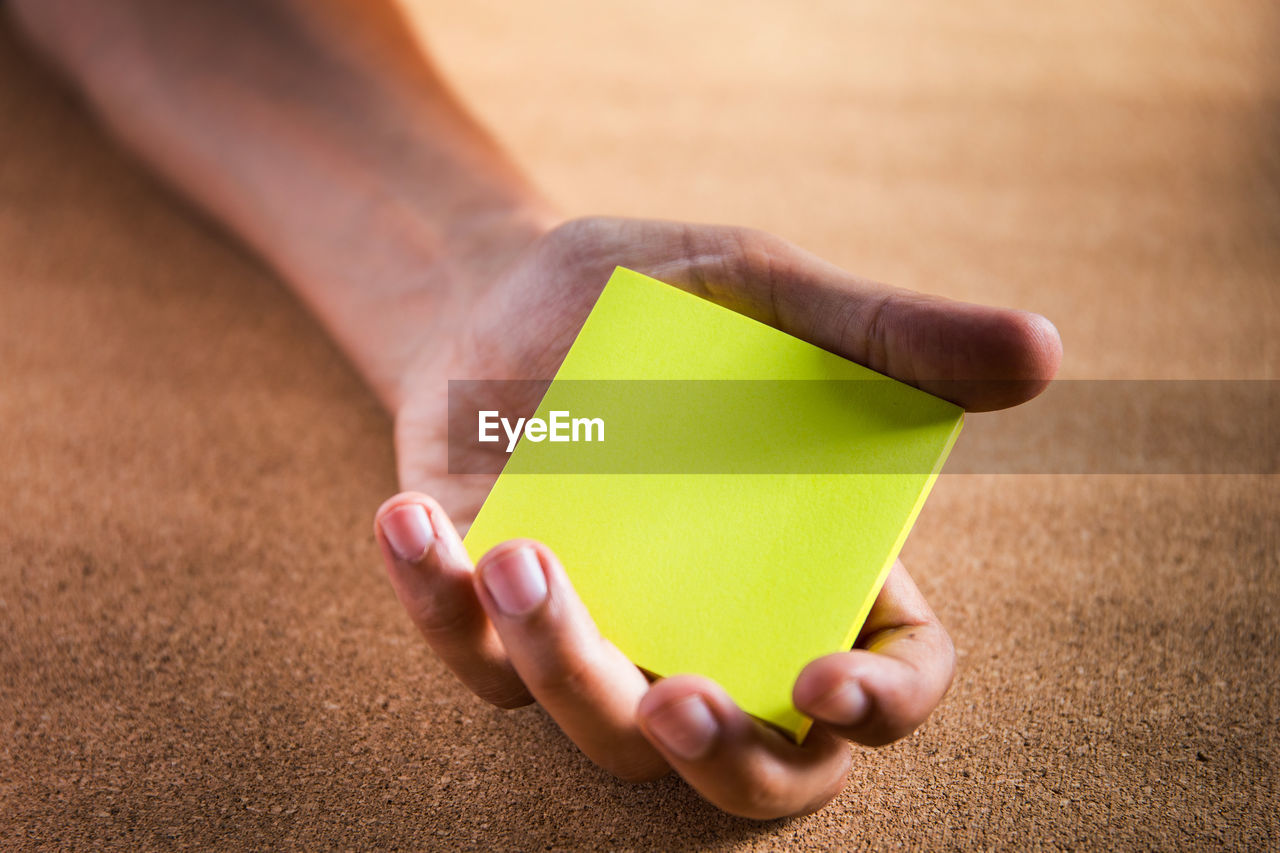 Close-up of person holding yellow paper