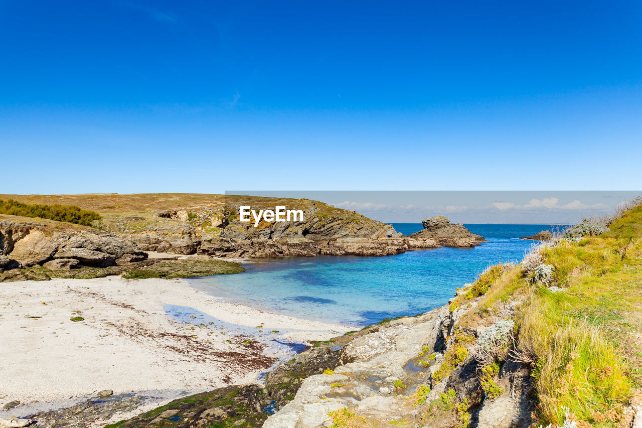 Scenic view of beach against blue sky