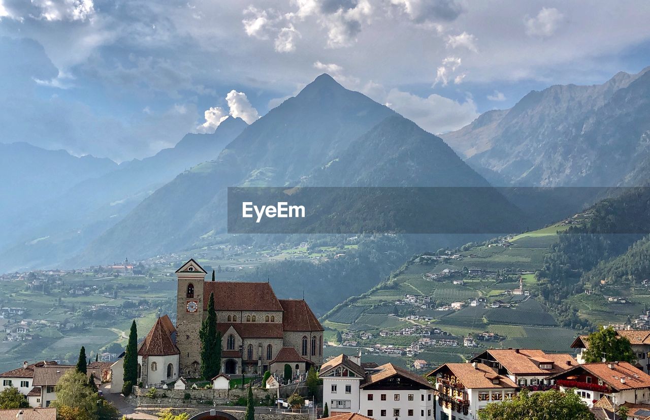 Aerial view of townscape and mountains against sky