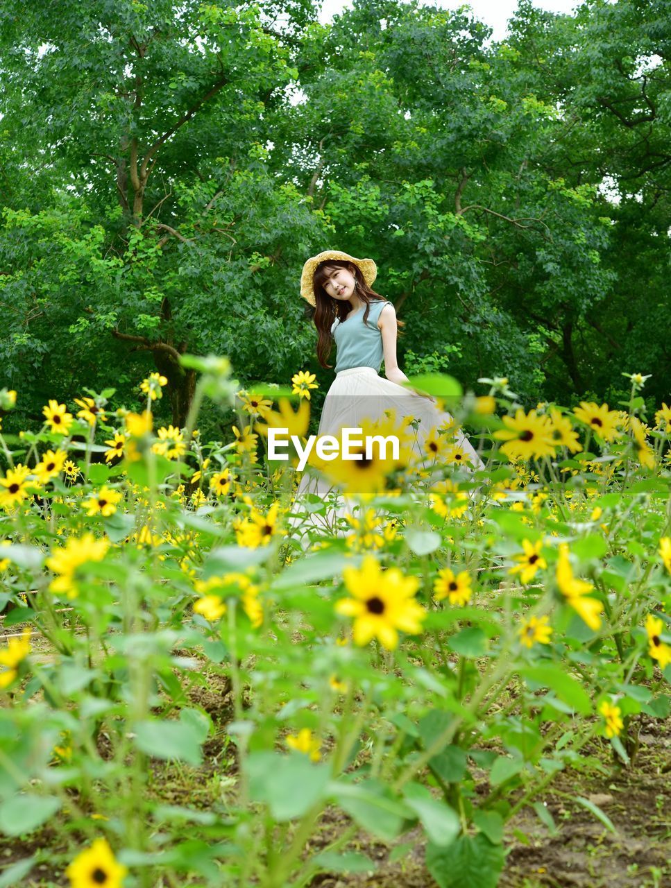 Woman with yellow flowers on field