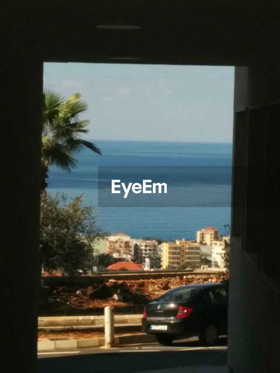 VIEW OF SEA WITH TREES IN BACKGROUND