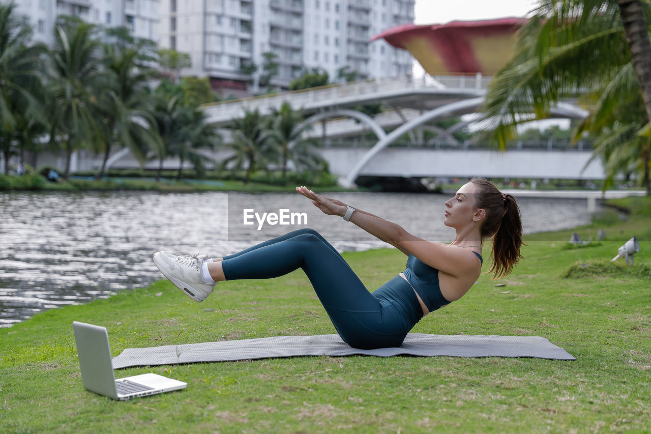 Side view of young woman lying on grass