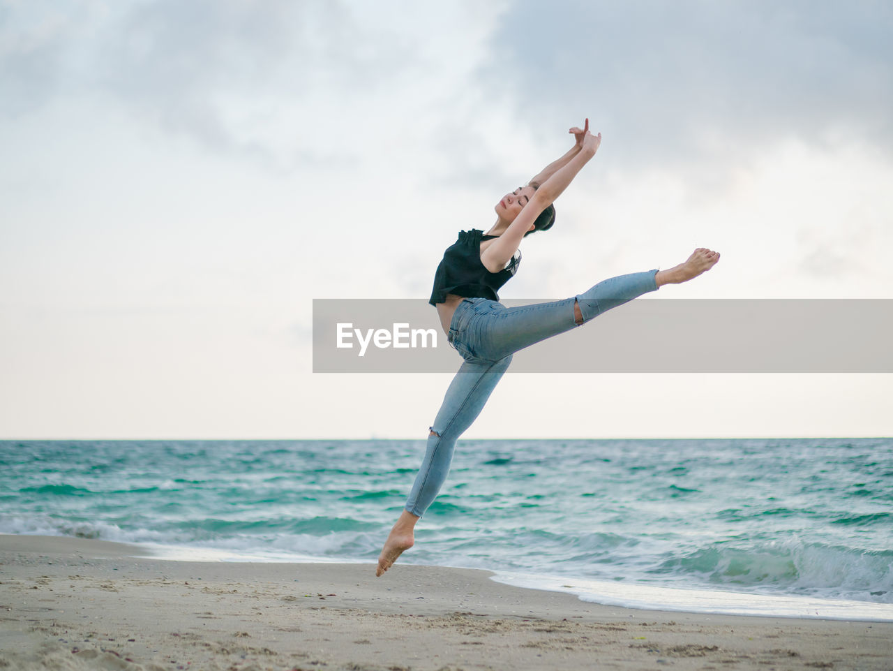 Full length of woman ballet dancing at beach