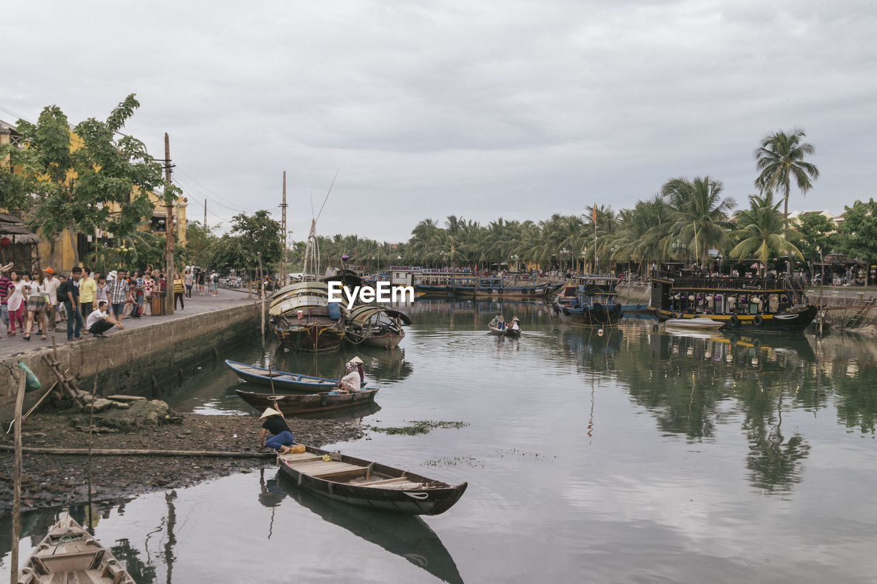 Boats moored in river against sky