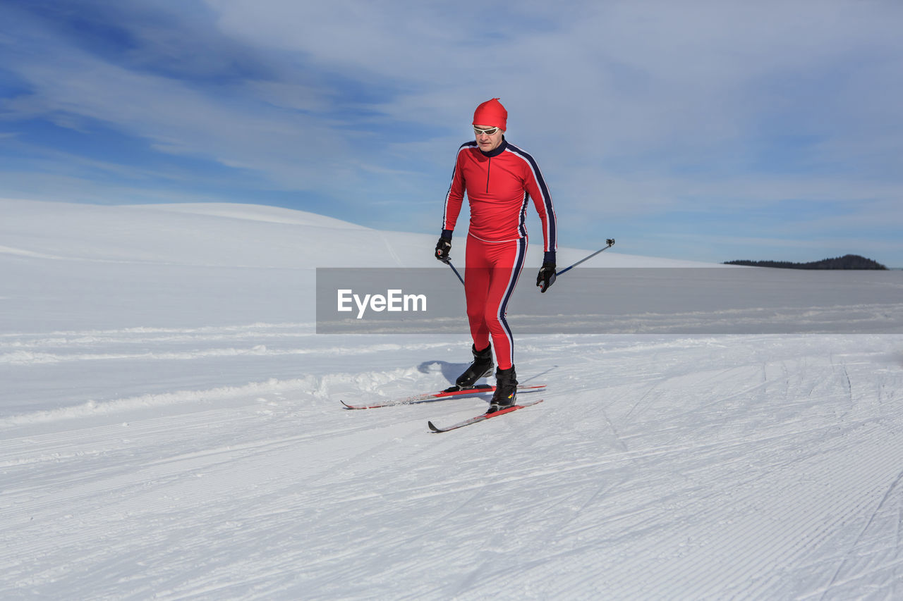 Man skiing on snowcapped mountain against sky