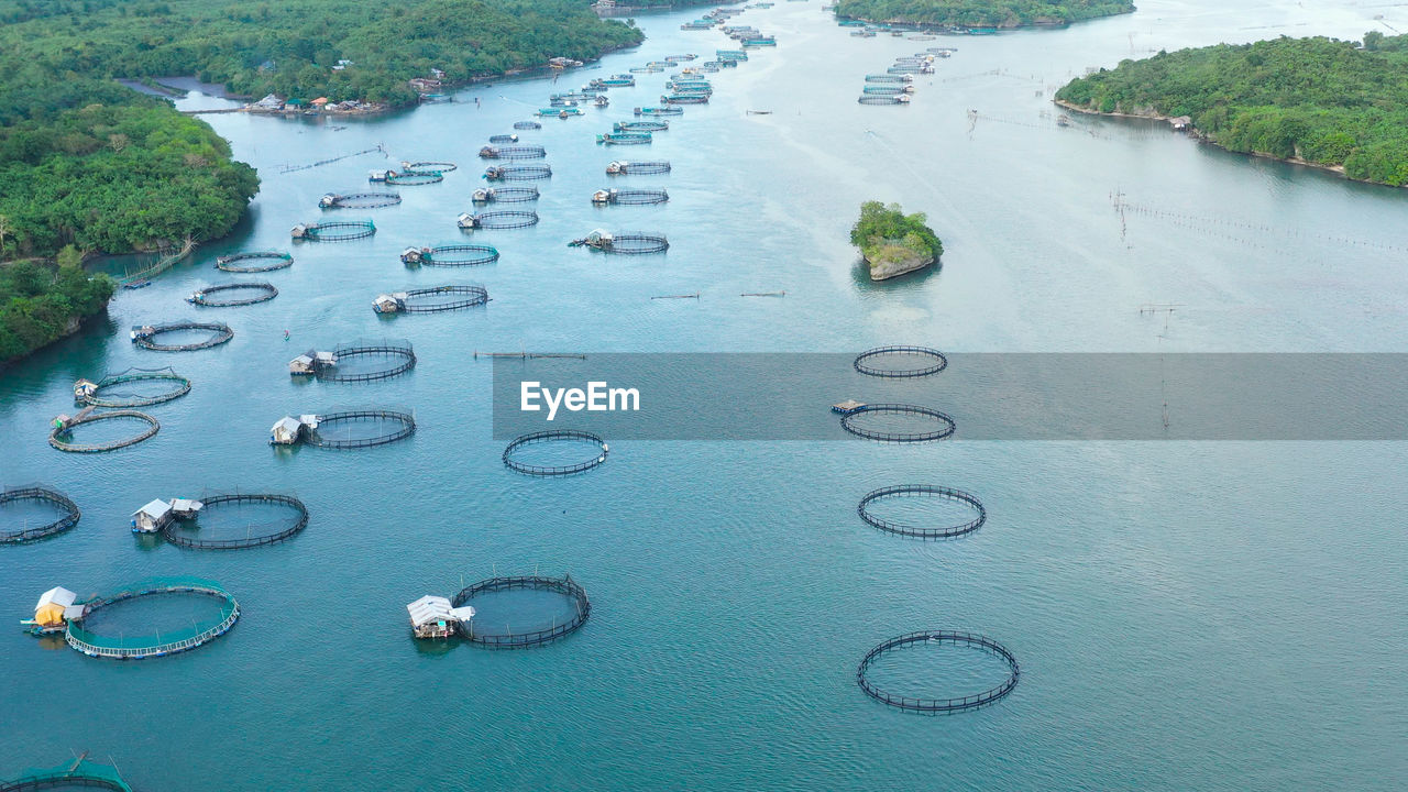 Aerial view of fish ponds for bangus, milkfish.  large scale traditional floating fish farms.