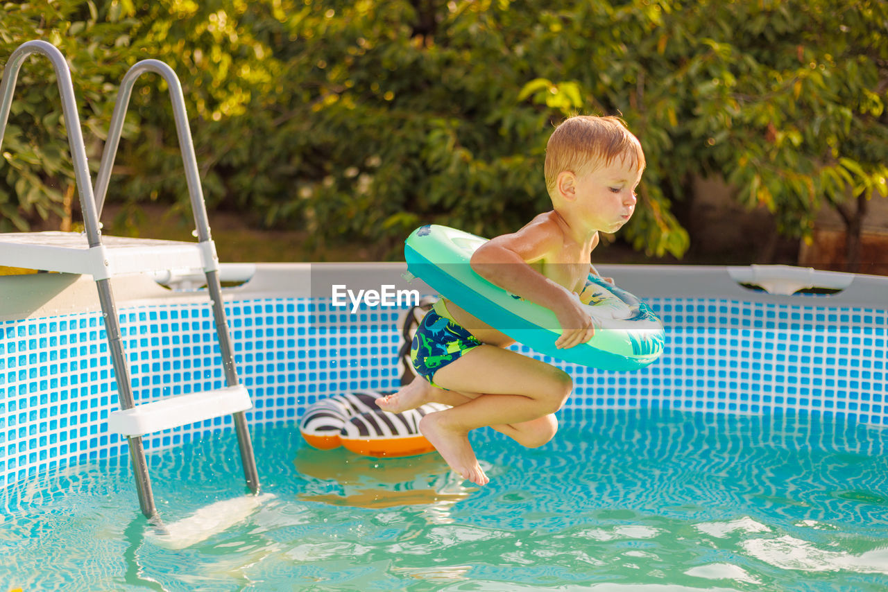 portrait of cute boy playing in swimming pool