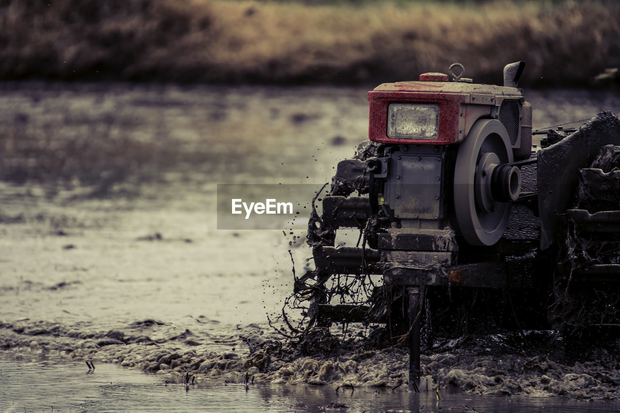 CLOSE-UP OF ABANDONED MACHINERY ON FIELD