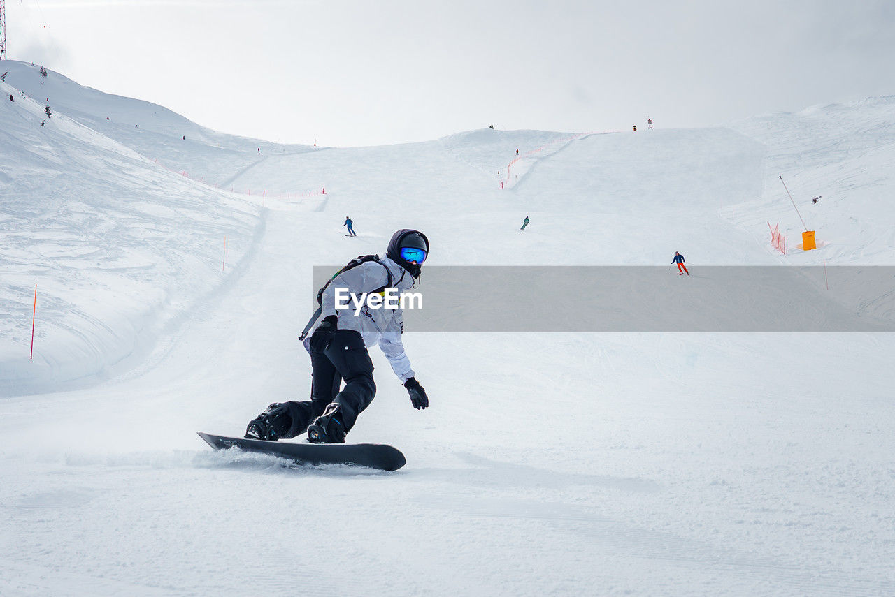 low angle view of people skiing on snow covered landscape