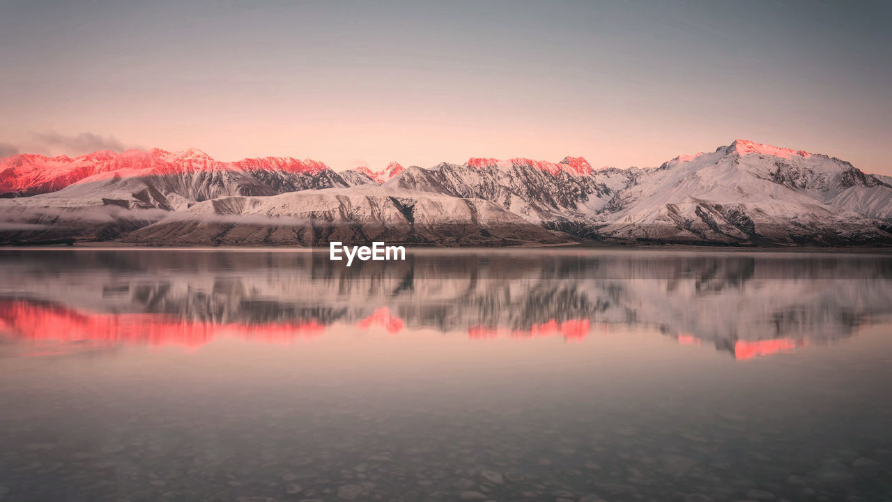 Scenic view of lake and mountains against sky during winter