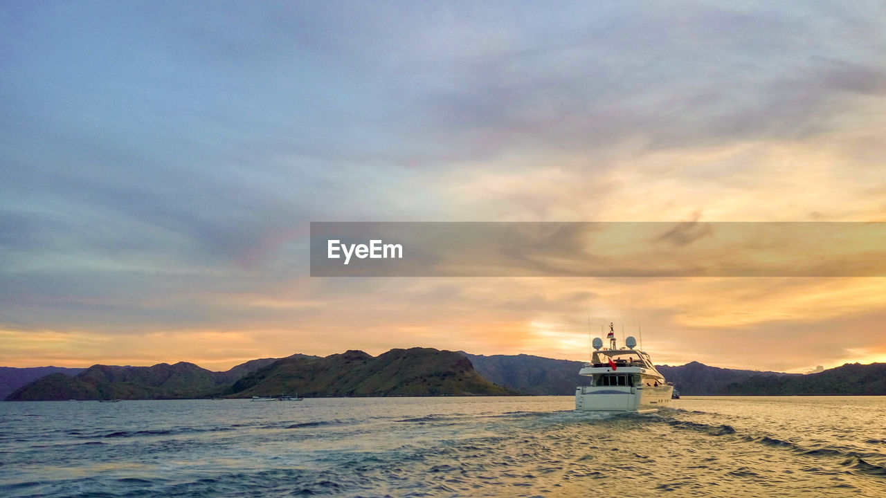 BOAT IN SEA AGAINST SKY DURING SUNSET