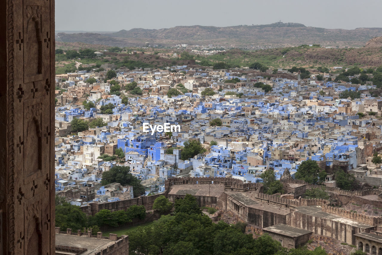 HIGH ANGLE VIEW OF CITYSCAPE AGAINST MOUNTAINS