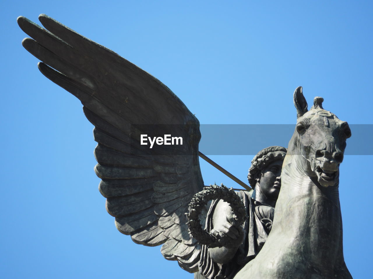 Low angle view of statue against clear blue sky