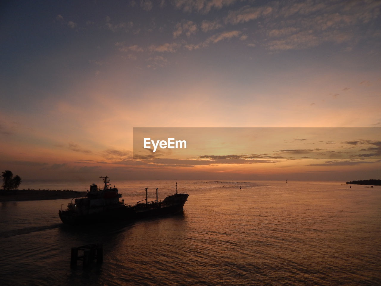 Ship in sea against sky during sunset