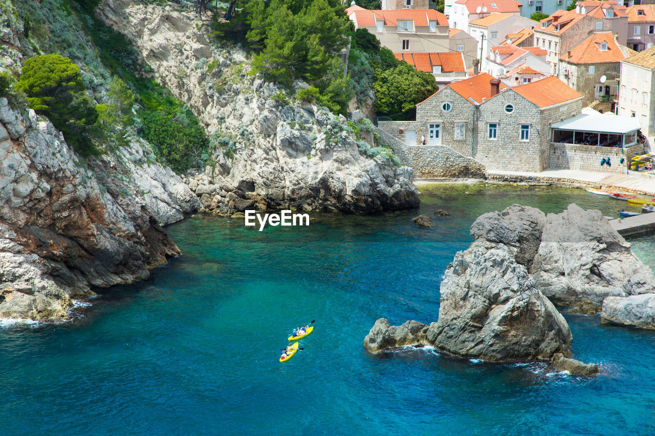 High angle view of rocks on adriatic sea against houses