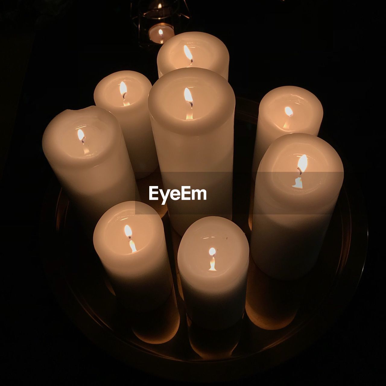 CLOSE-UP OF ILLUMINATED CANDLE ON TABLE