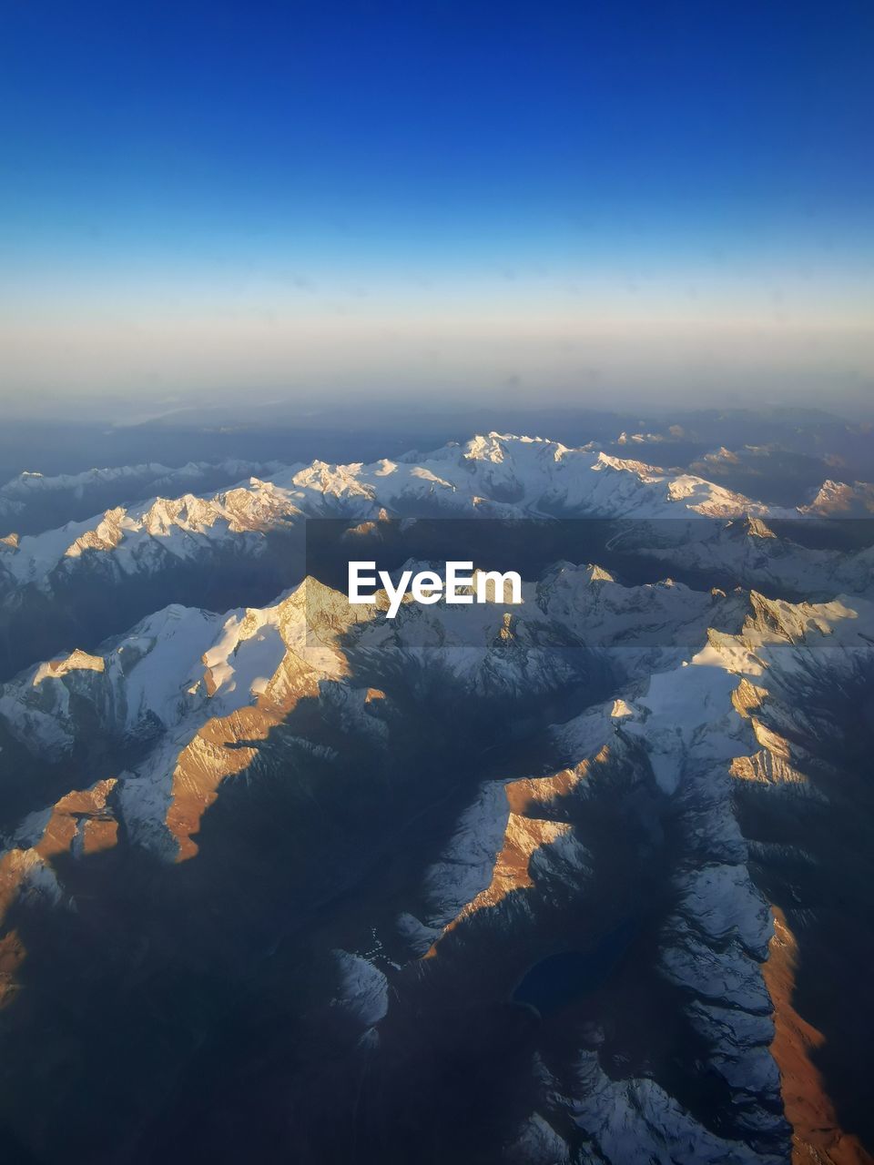AERIAL VIEW OF SNOWCAPPED MOUNTAIN AGAINST SKY DURING WINTER