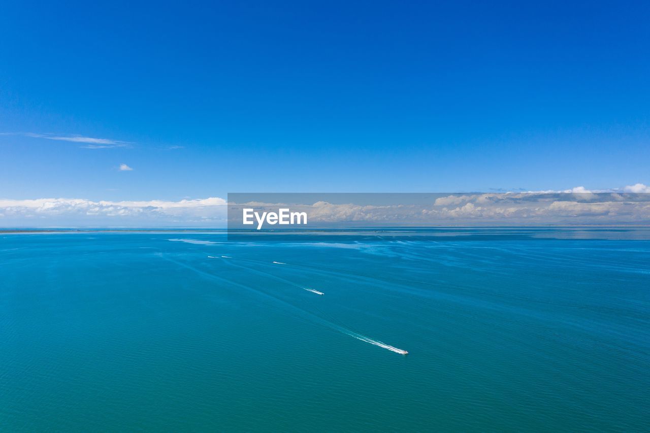 AERIAL VIEW OF SEA AGAINST BLUE SKY