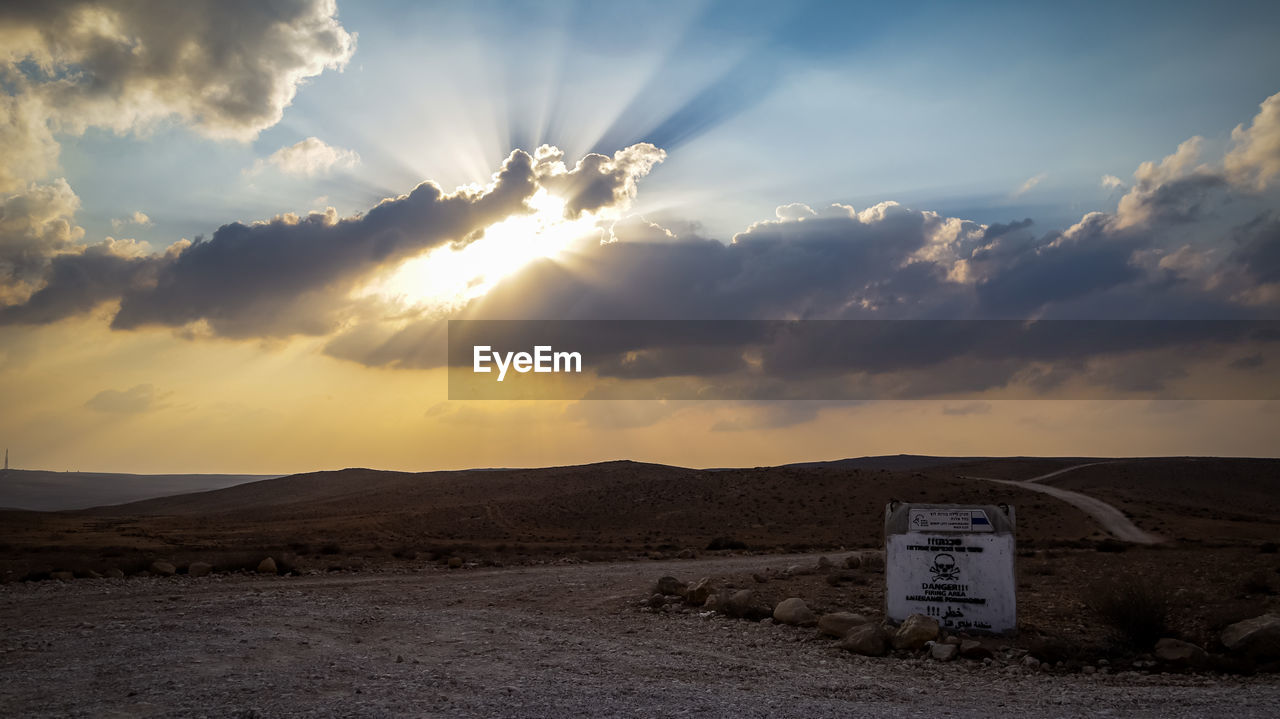 INFORMATION SIGN ON FIELD AGAINST SKY