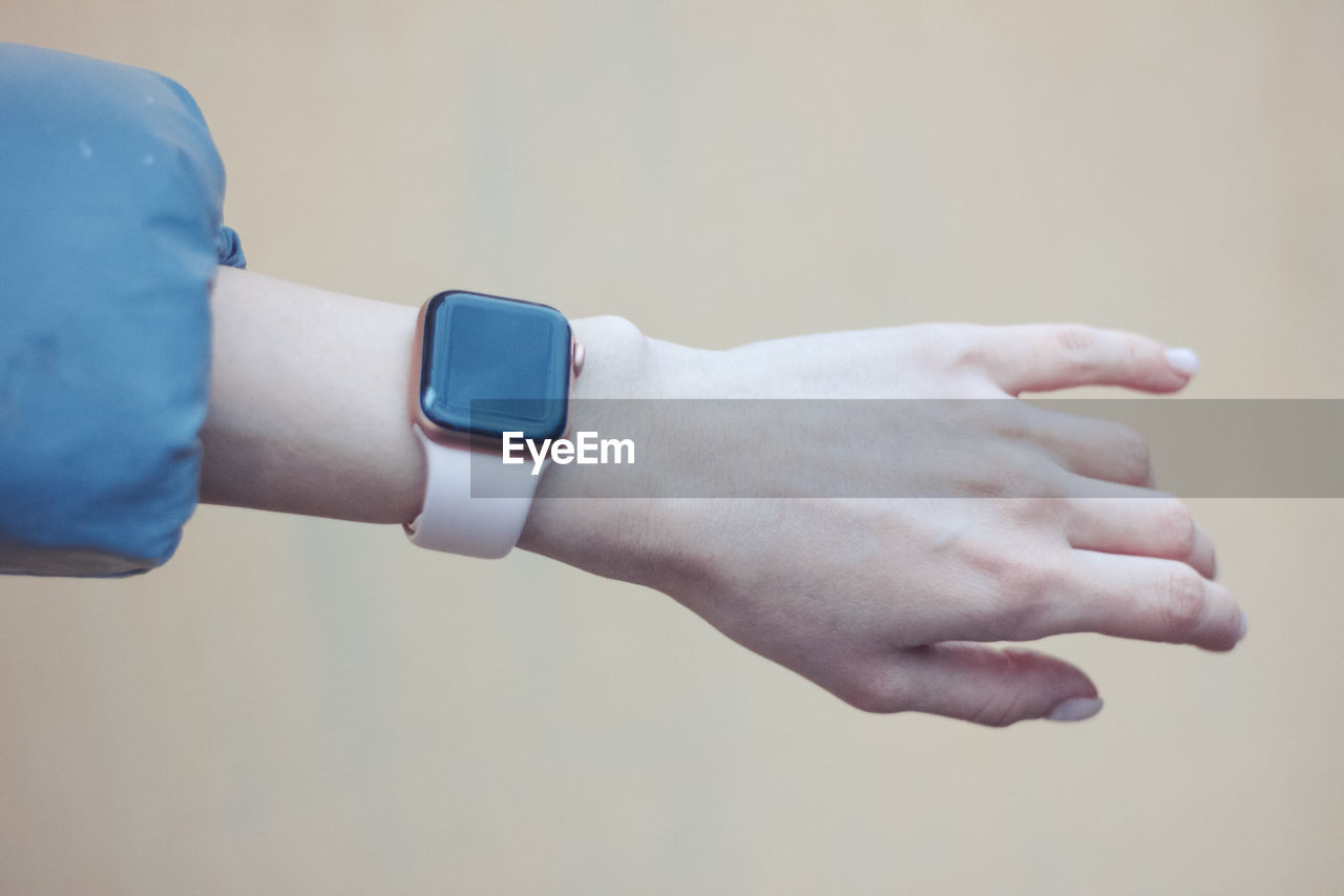 Smart watch on a woman's hand. beige background. technology