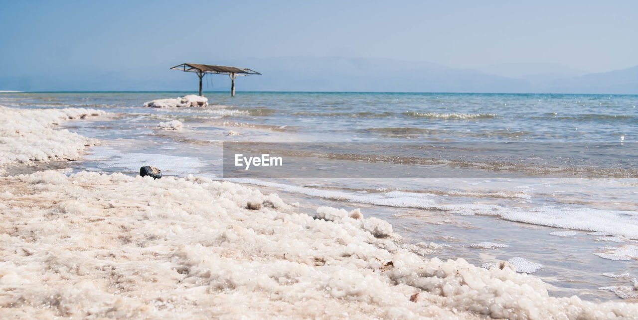 Salt on shore of dead sea against sky