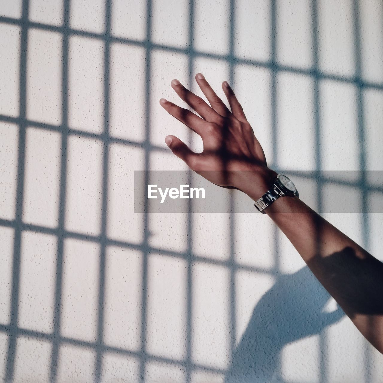 Close-up of human hand touching white wall