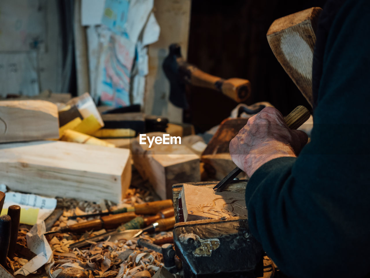 Midsection of man carving wood in workshop