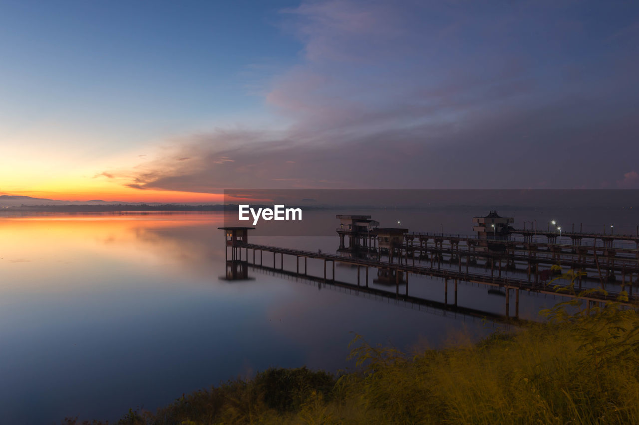Pier over sea against sky during sunset