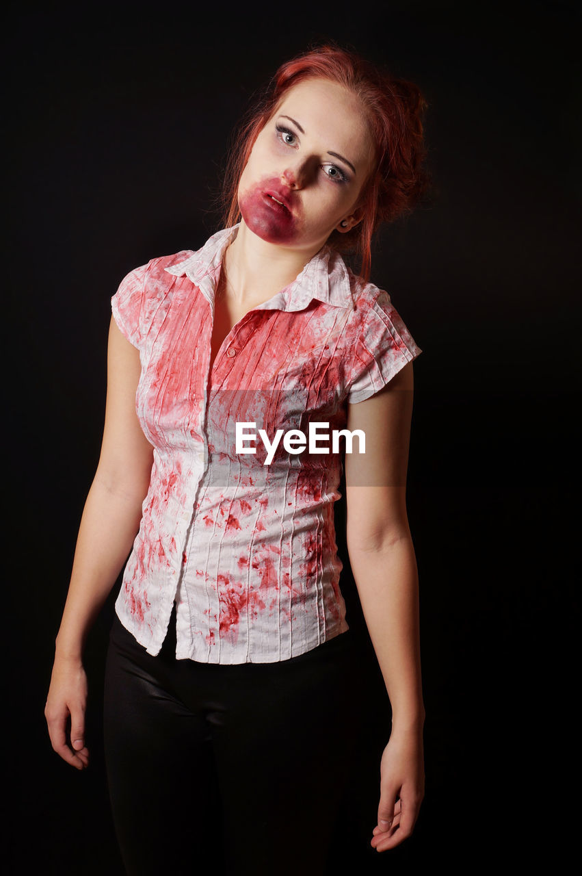 Portrait of woman with make-up for halloween against black background