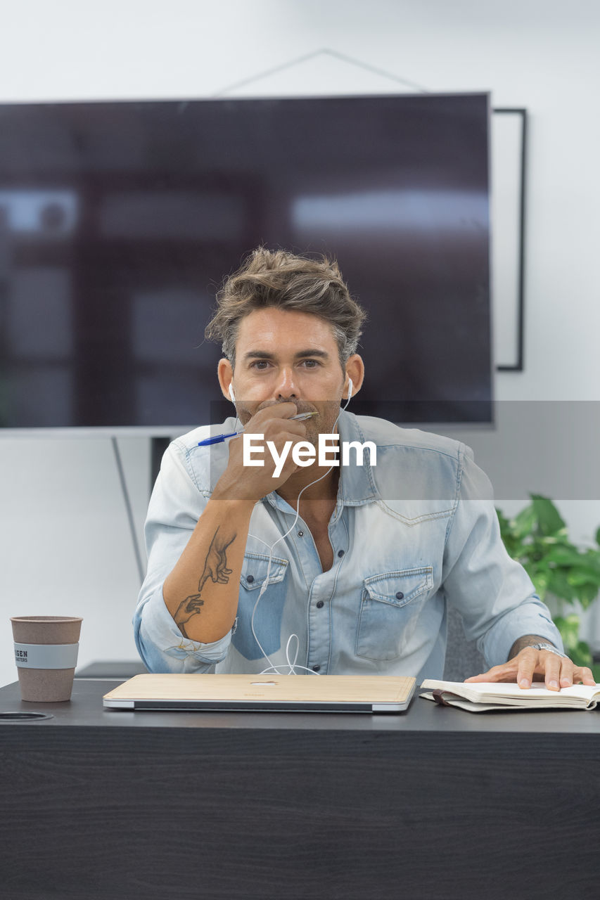 Portrait of a focused man sitting at desktop in modern office