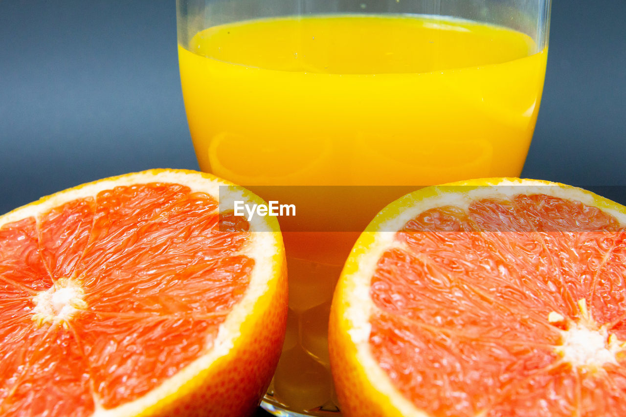 Orange or grapefruit with a glass of orange juice on black background
