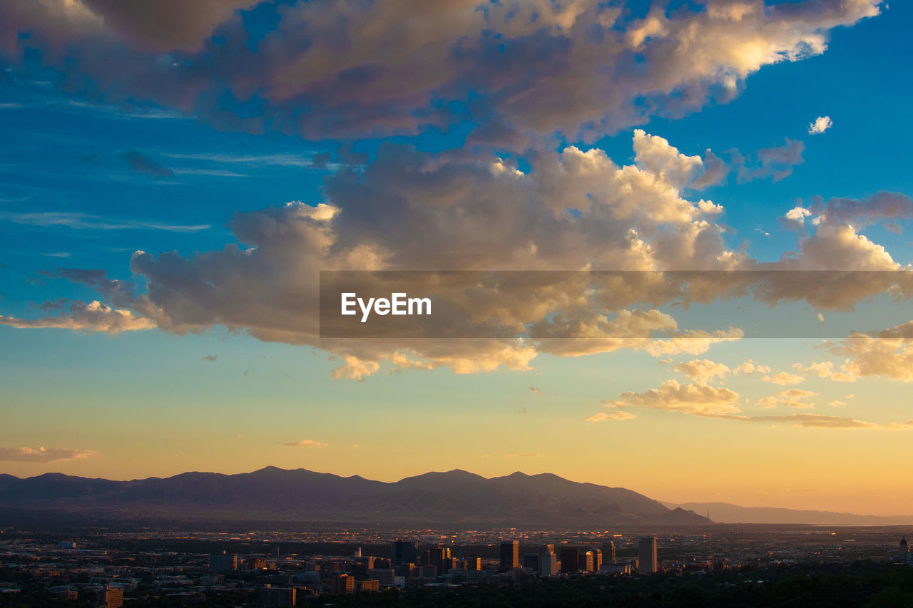 SCENIC VIEW OF TOWN AGAINST SKY AT SUNSET