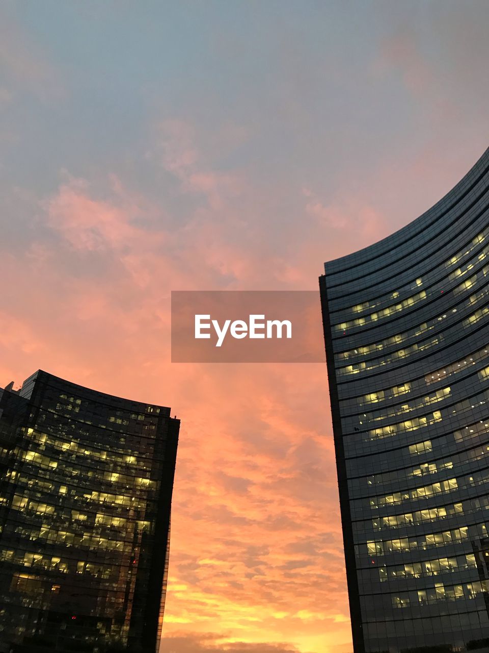 LOW ANGLE VIEW OF BUILDINGS AGAINST SKY AT SUNSET