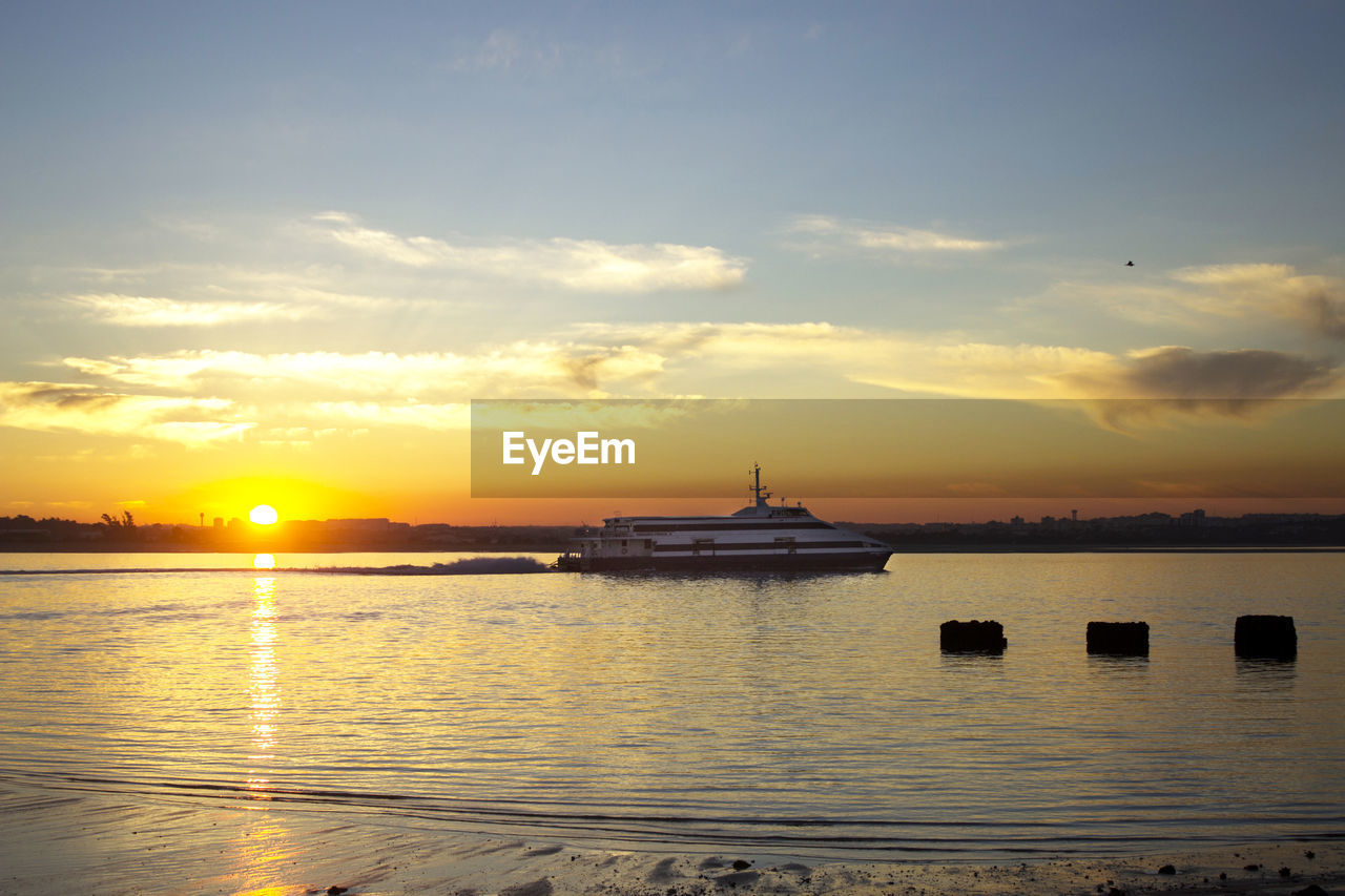 Sailboats in sea against sky during sunset