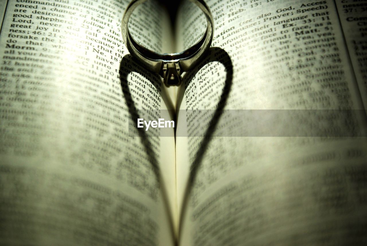 Close-up of ring shadow making heart shape on book