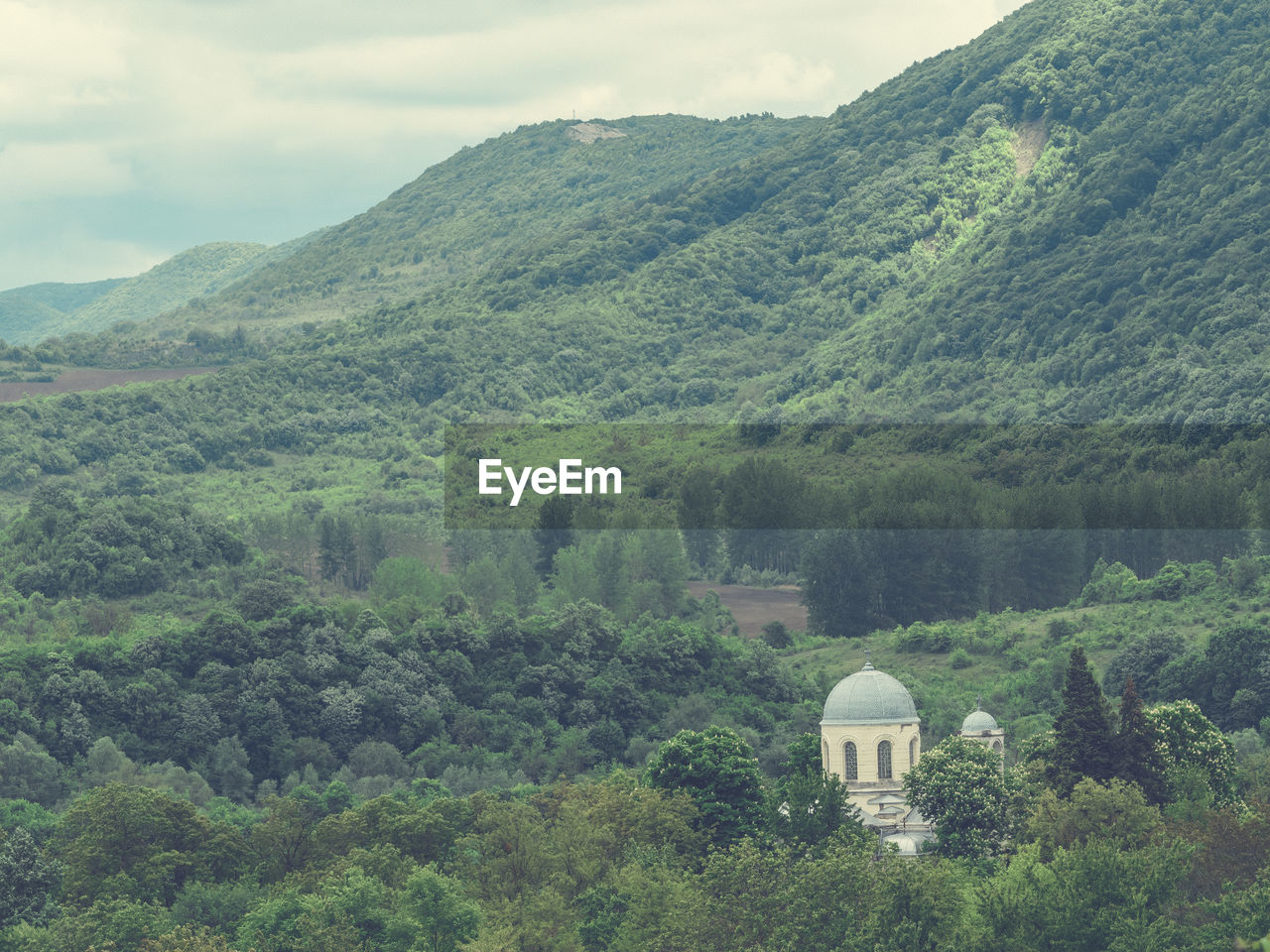 High angle view of church amidst trees against mountain