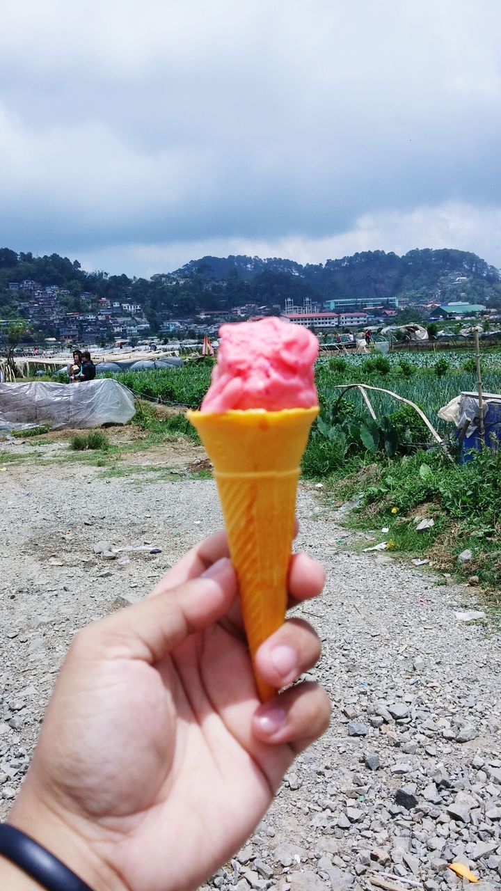 PERSON HOLDING ICE CREAM CONE