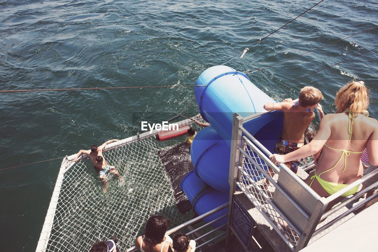 HIGH ANGLE VIEW OF PEOPLE SITTING ON BOAT