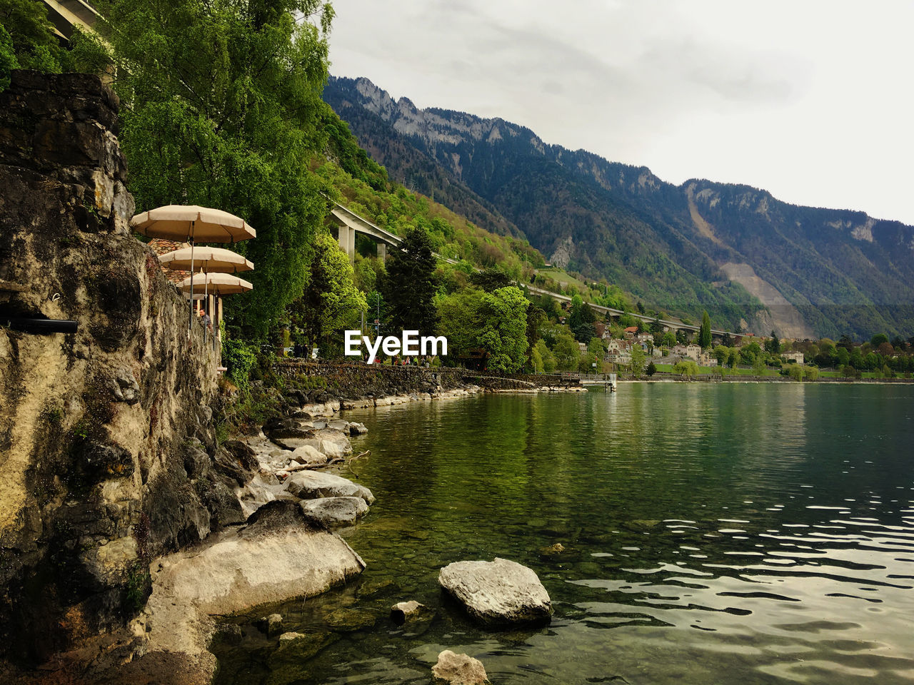 Scenic view of river by mountains against sky