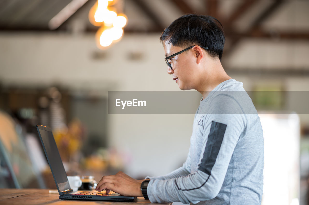 Side view of man working on table