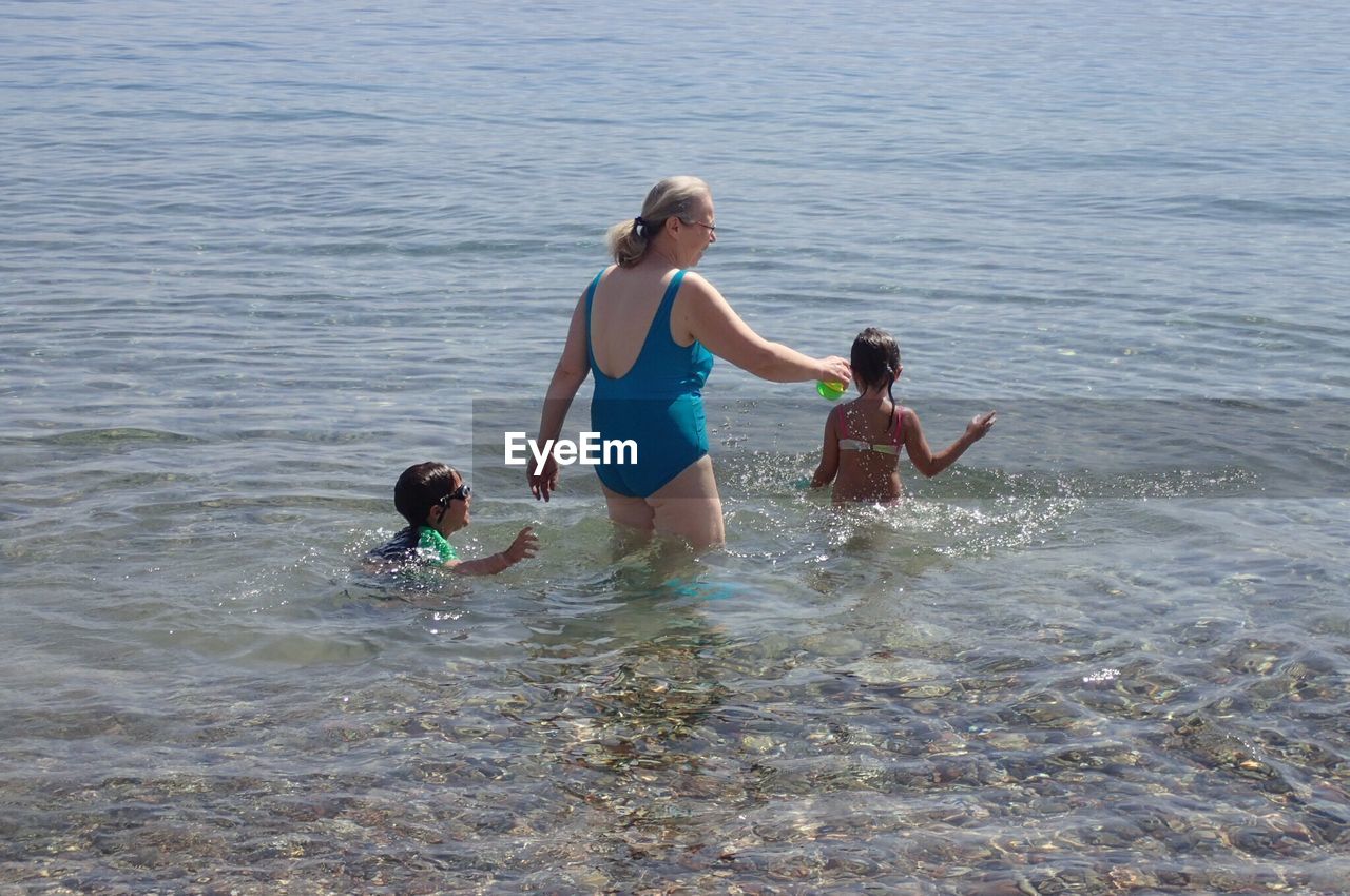 Rear view of family playing in sea