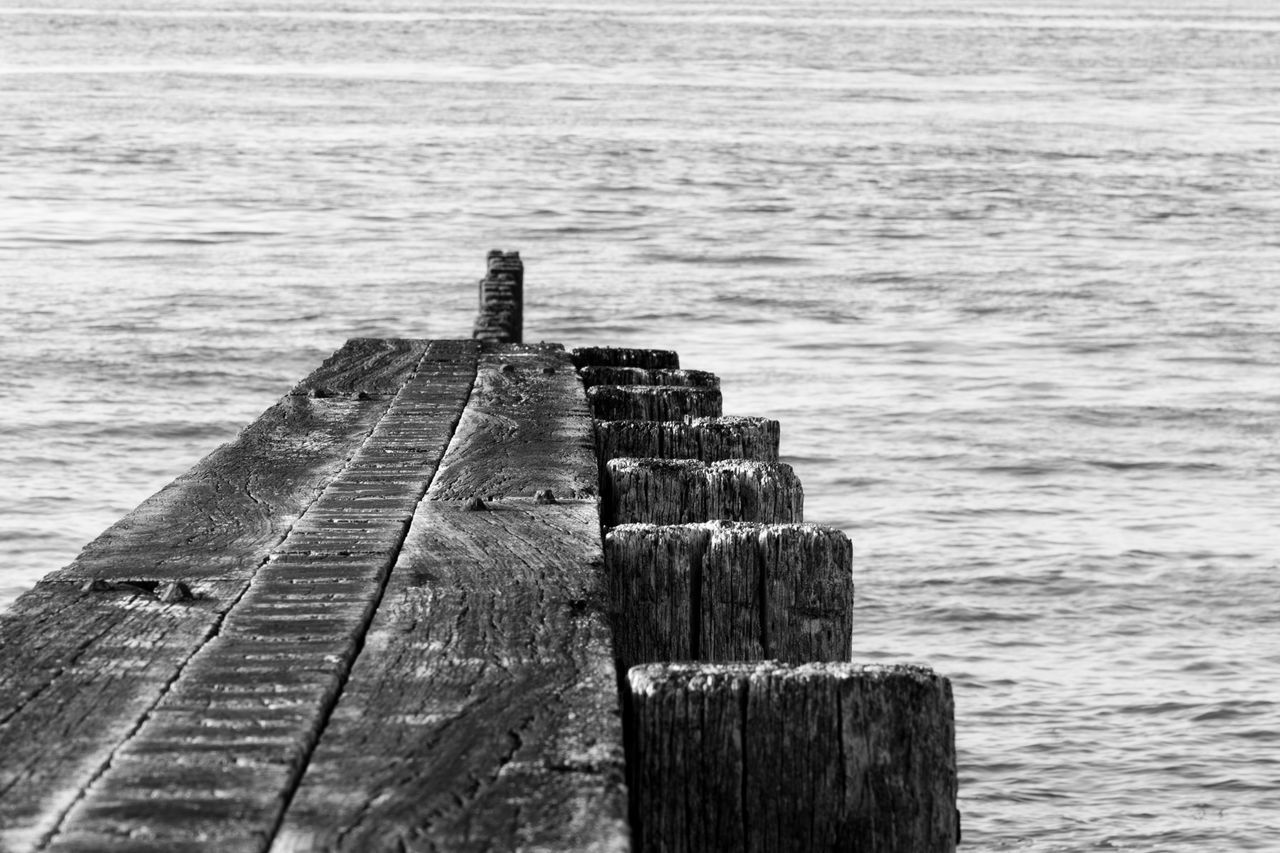 WOODEN POSTS ON SEA