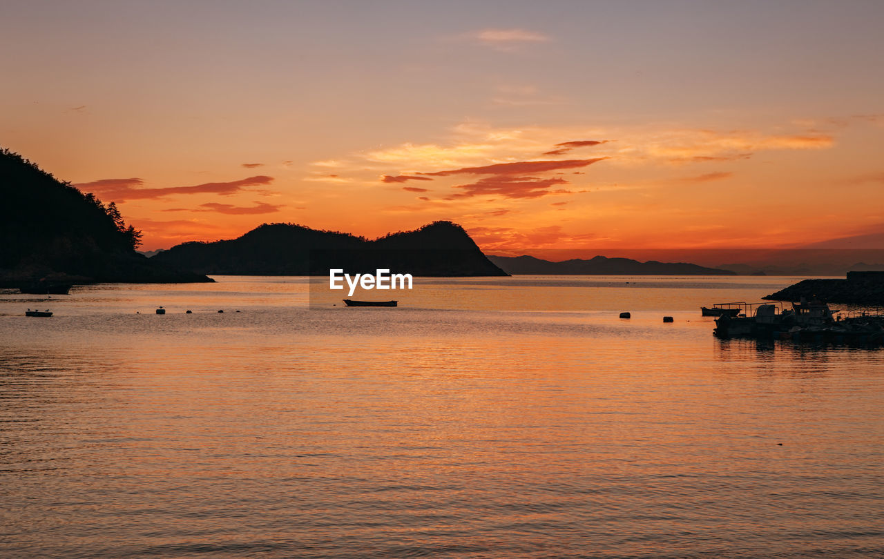 Scenic view of sea against orange sky