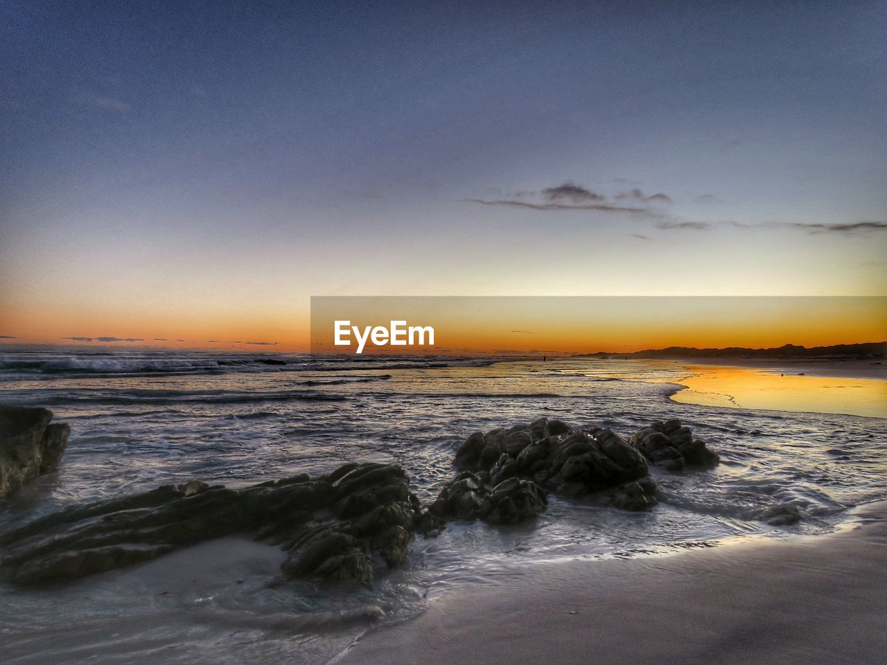 SCENIC VIEW OF BEACH DURING SUNSET