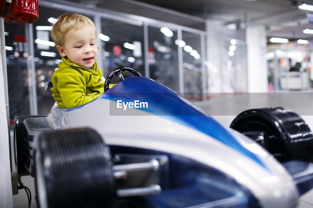 Boy sitting in car at showroom