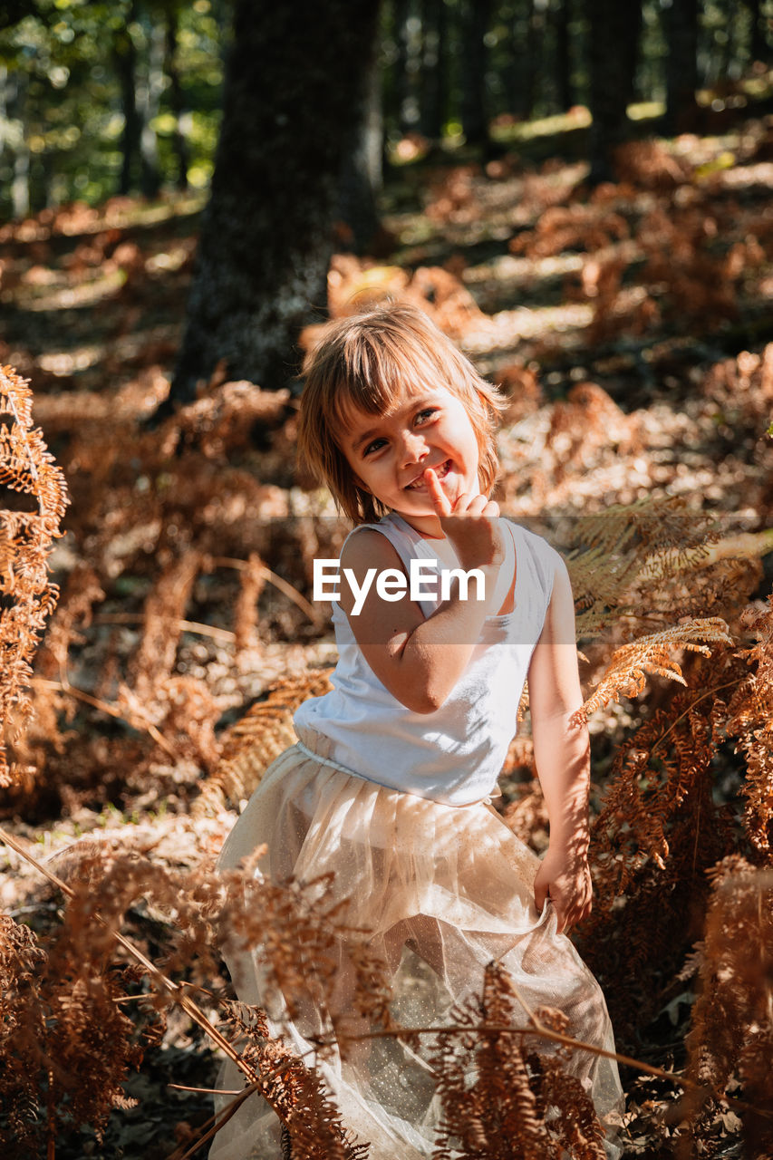 Girl sitting on land in forest