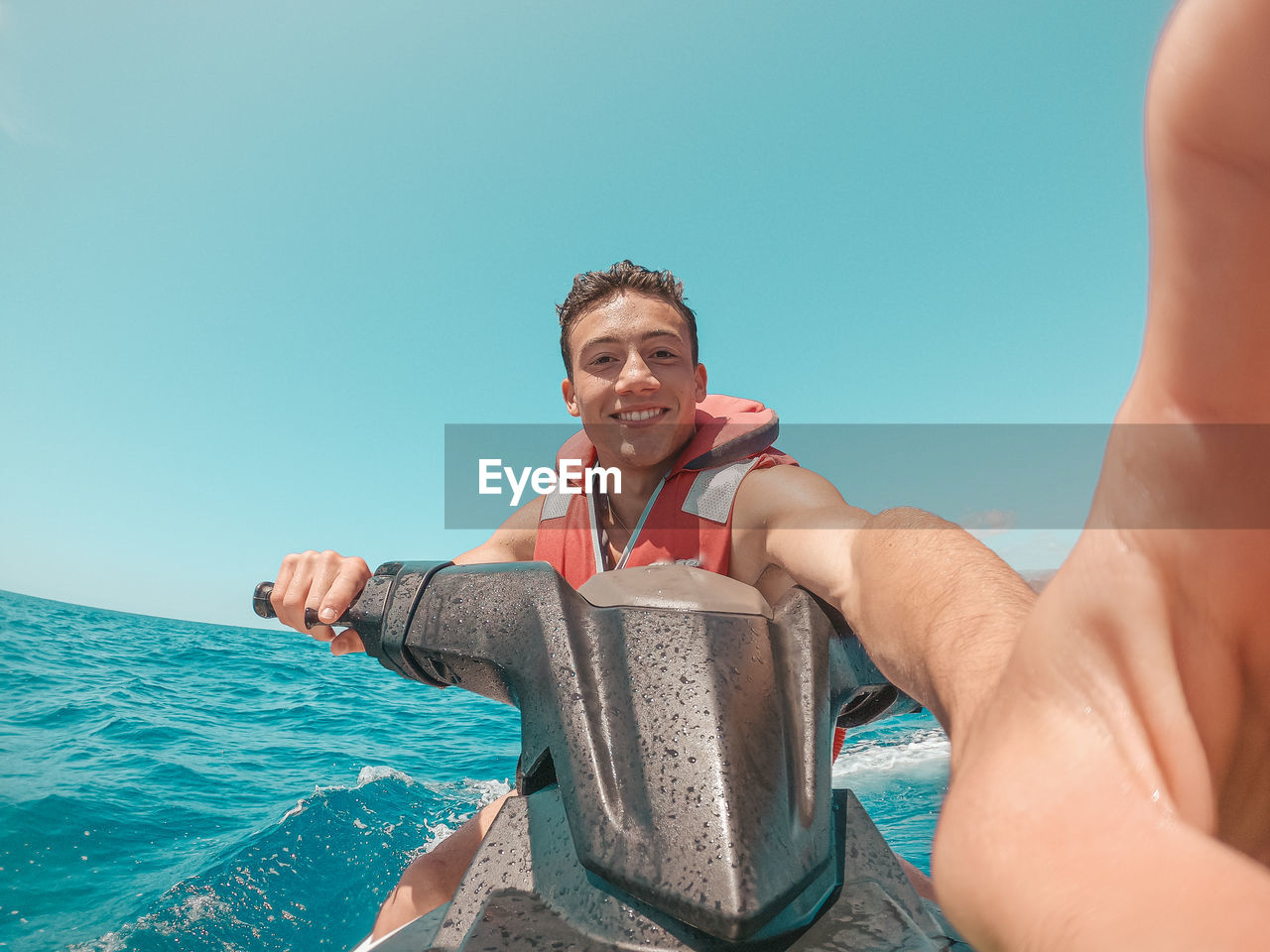 Portrait of young man in sea against clear sky