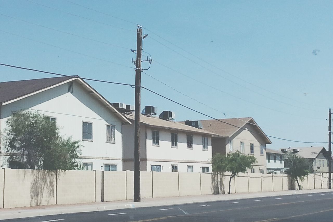 HOUSES BY TREE AGAINST CLEAR SKY